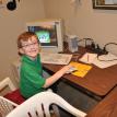 Matthew at the computer in the computer lab and practice room.